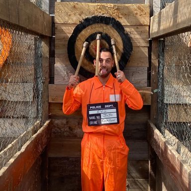 Lancer de haches EVG Perpignan : futur marié en combinaison orange avec 3 haches plantées juste au-dessus – activité Torreilles 66