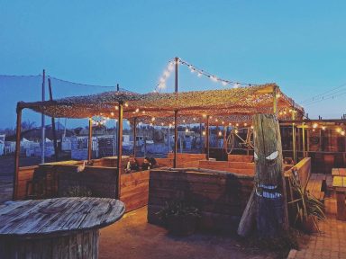 Terrasse illuminée et bar en plein air du Bar à Haches Torreilles – Perpignan : l’endroit idéal pour l’apéro après votre EVG !