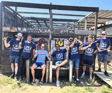 Un groupe de six personnes posant ensemble devant une structure en bois.